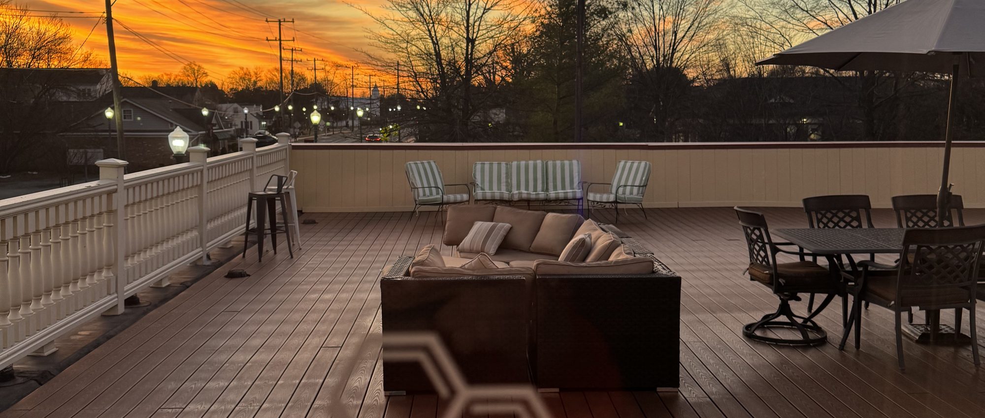 The Hive's rooftop terrace glowing at golden hour with the hexagon emblem and skyline beyond